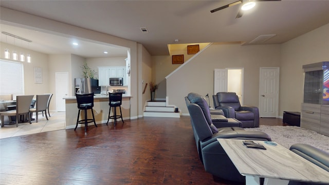 living room featuring wood-type flooring and ceiling fan