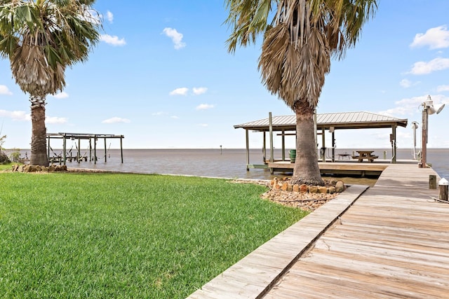 dock area with a water view, a gazebo, and a yard