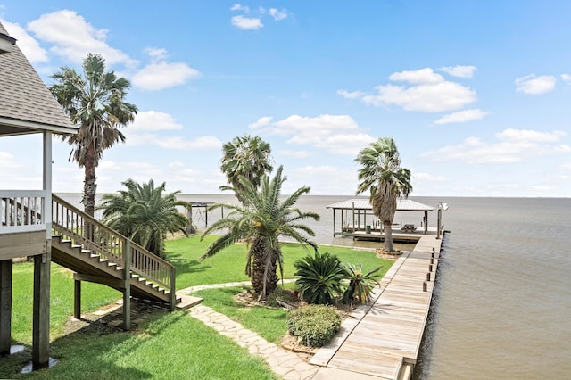 view of dock featuring a water view and a lawn