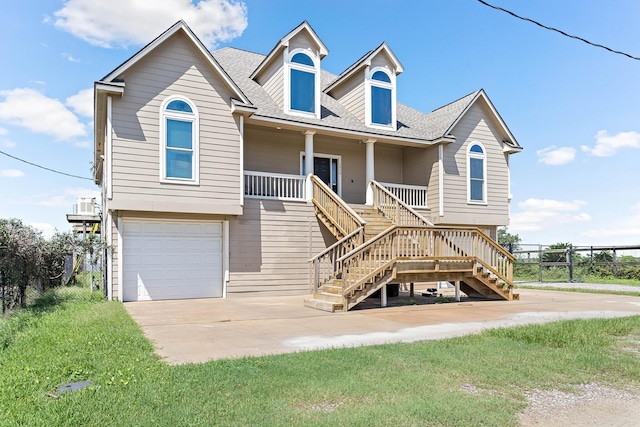 view of front of house with a front yard, covered porch, and a garage