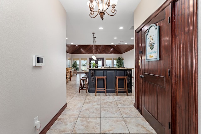 interior space with light tile patterned floors, wooden ceiling, high vaulted ceiling, a chandelier, and sink