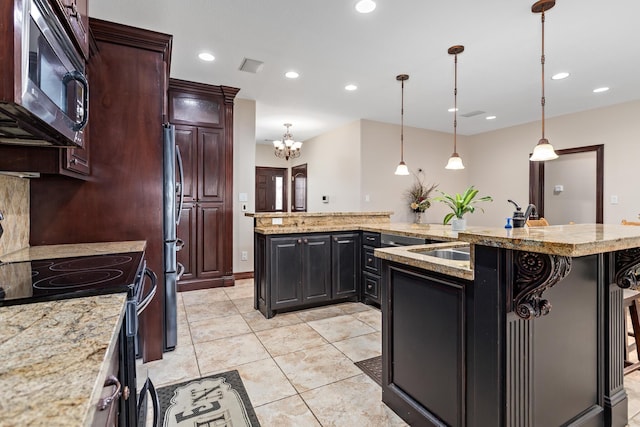 kitchen with stainless steel appliances, a kitchen bar, hanging light fixtures, and an island with sink