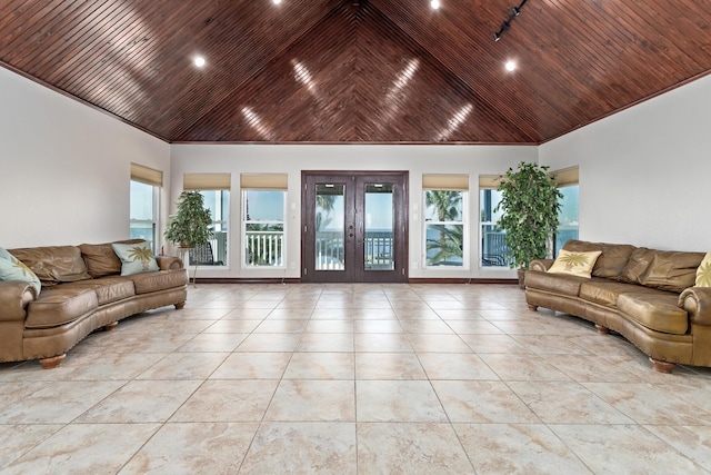 tiled living room with high vaulted ceiling and french doors