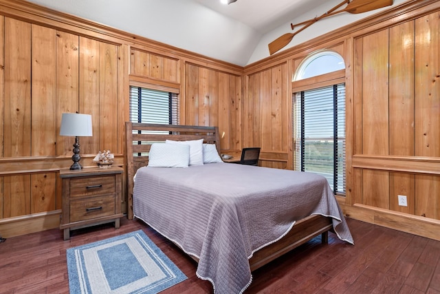 bedroom with lofted ceiling, dark hardwood / wood-style floors, and multiple windows