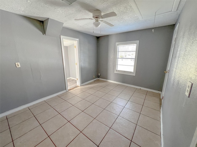 tiled spare room featuring a textured ceiling and ceiling fan