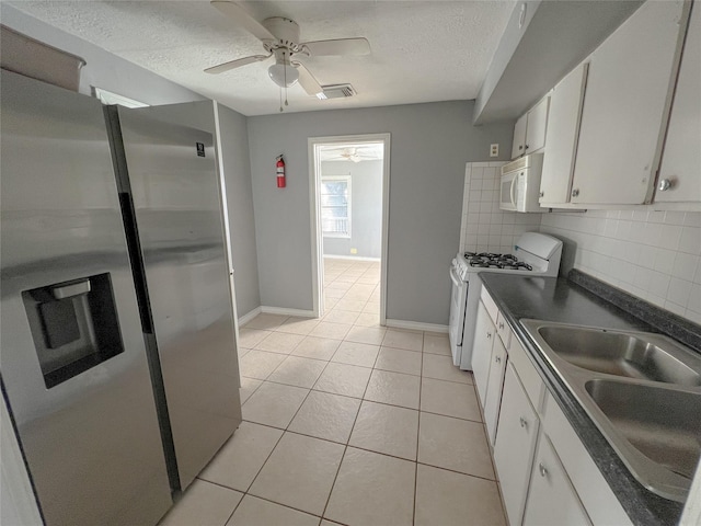 kitchen featuring white appliances, white cabinets, decorative backsplash, sink, and light tile patterned floors