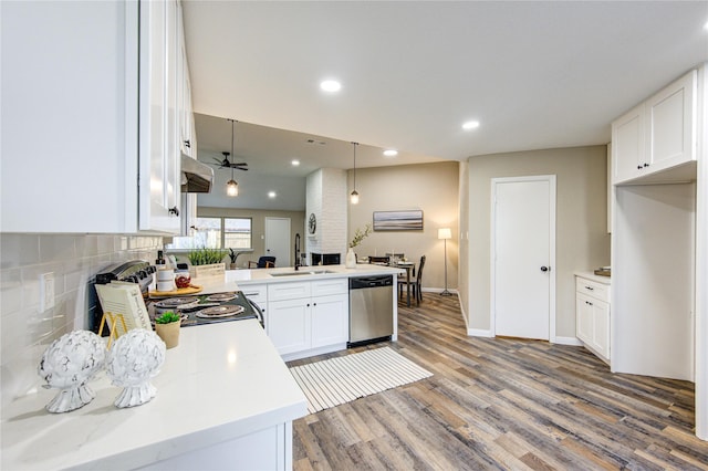 kitchen with appliances with stainless steel finishes, white cabinetry, sink, kitchen peninsula, and ceiling fan