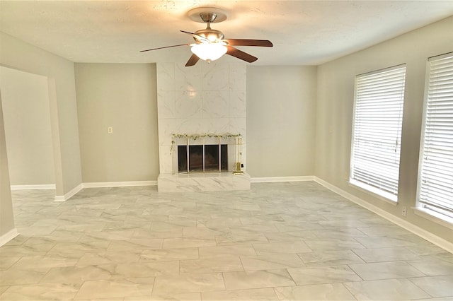 unfurnished living room with a premium fireplace and ceiling fan