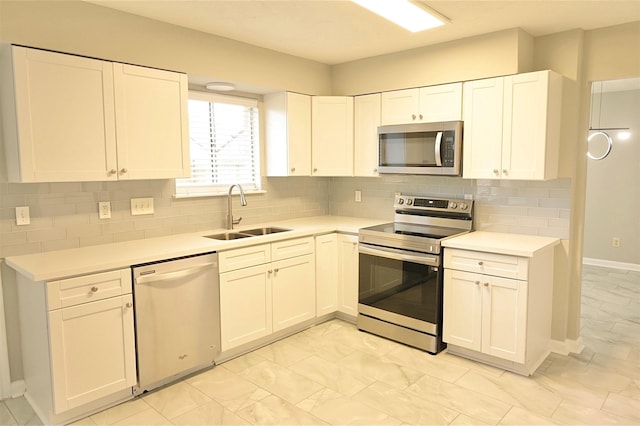 kitchen with backsplash, sink, white cabinetry, and appliances with stainless steel finishes