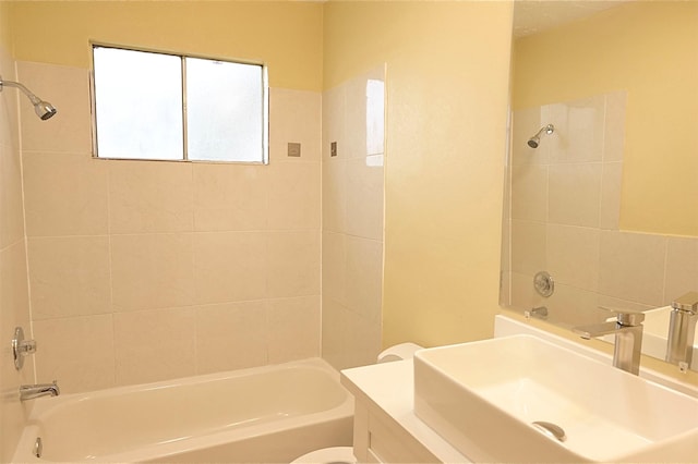 full bathroom with toilet, tiled shower / bath combo, and vanity