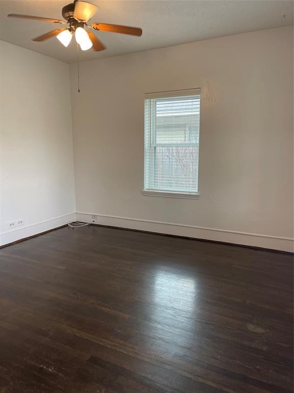 spare room featuring ceiling fan and dark wood-type flooring