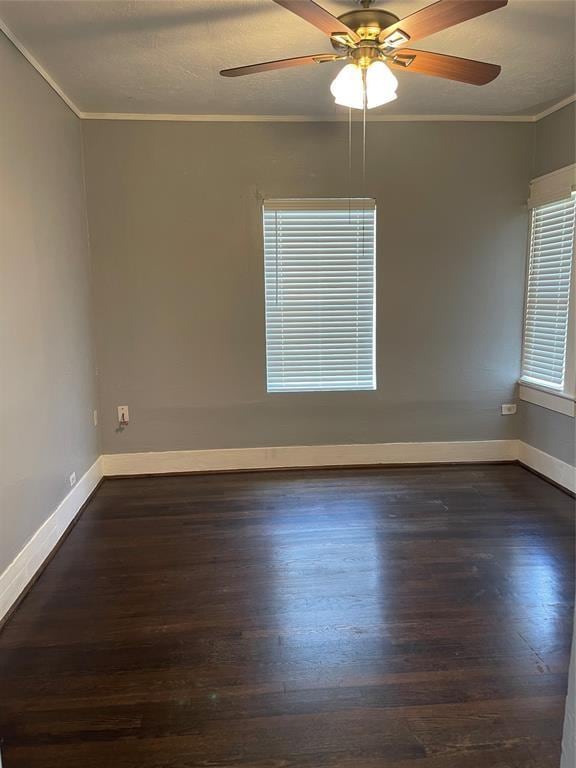 spare room with dark wood-type flooring, crown molding, and ceiling fan