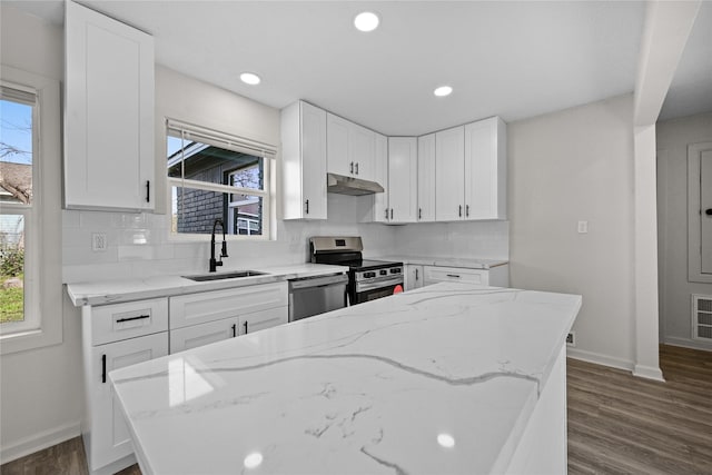 kitchen featuring light stone counters, decorative backsplash, white cabinets, and stainless steel appliances