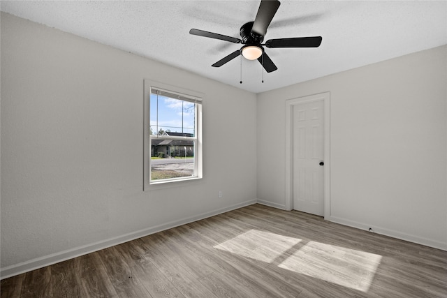 empty room with a textured ceiling, ceiling fan, and light hardwood / wood-style floors