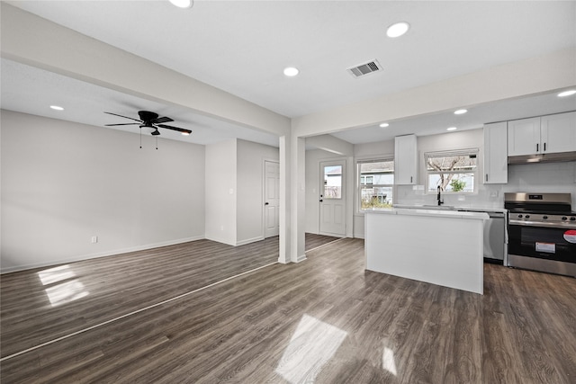 kitchen with white cabinetry, ceiling fan, stainless steel appliances, dark hardwood / wood-style floors, and backsplash