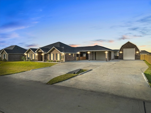 ranch-style home featuring a garage and a lawn