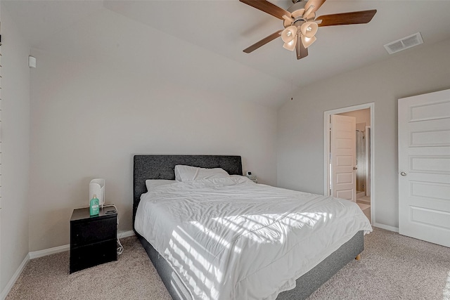 carpeted bedroom featuring vaulted ceiling, ceiling fan, and ensuite bath