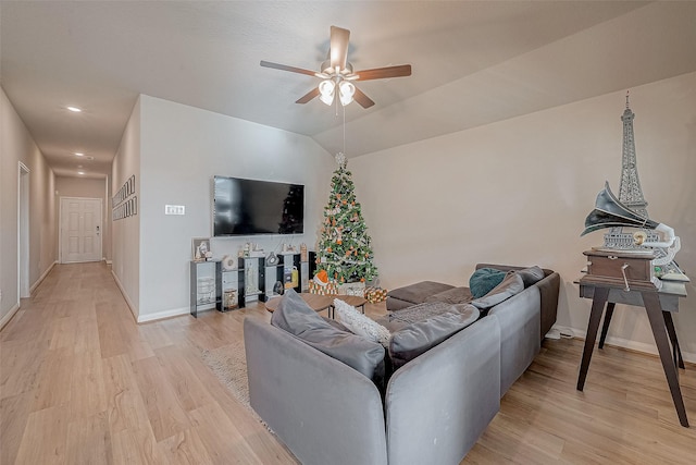 living room featuring ceiling fan, light hardwood / wood-style flooring, and lofted ceiling