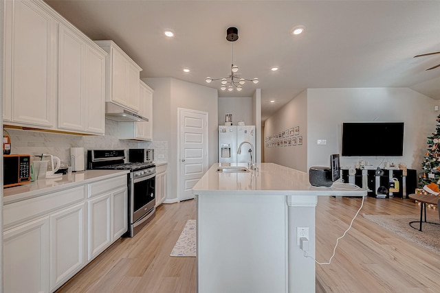 kitchen with a center island with sink, appliances with stainless steel finishes, decorative light fixtures, white cabinets, and sink