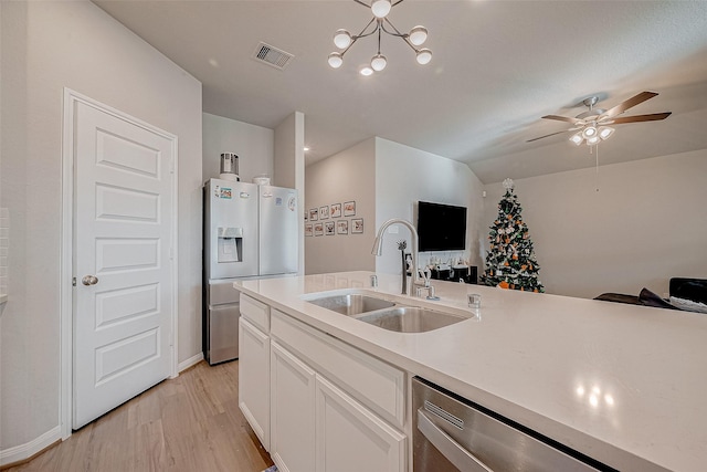 kitchen with white cabinets, appliances with stainless steel finishes, lofted ceiling, sink, and light hardwood / wood-style flooring