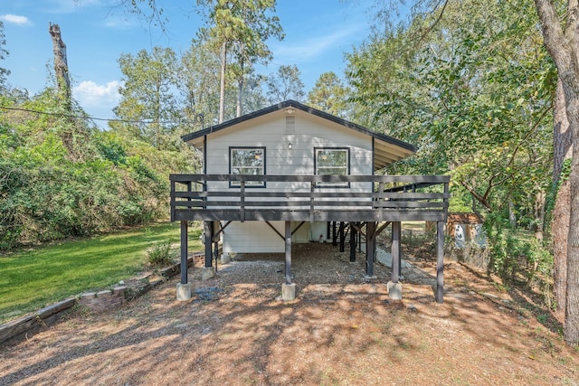 back of property with a lawn and a wooden deck