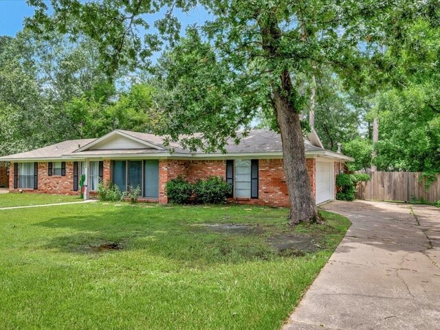 ranch-style home with a garage and a front yard