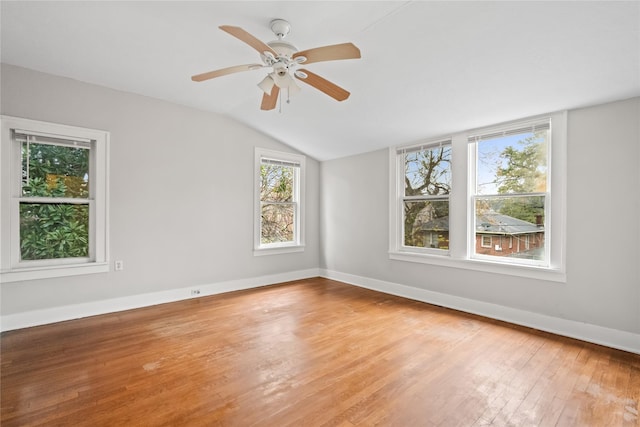 empty room with ceiling fan, wood-type flooring, lofted ceiling, and a healthy amount of sunlight