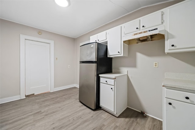 kitchen with white cabinetry, stainless steel fridge, light hardwood / wood-style flooring, and lofted ceiling