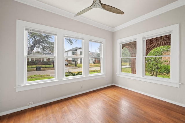 unfurnished sunroom featuring ceiling fan and a healthy amount of sunlight