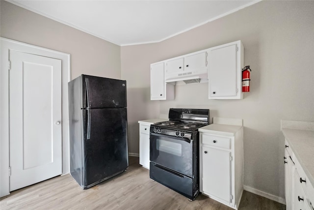 kitchen with light hardwood / wood-style floors, white cabinets, and black appliances