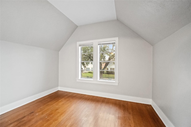 bonus room with vaulted ceiling and hardwood / wood-style flooring