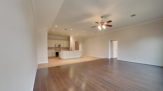 unfurnished living room featuring ceiling fan, light wood-type flooring, sink, and ornamental molding