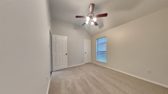 carpeted empty room with ceiling fan and lofted ceiling