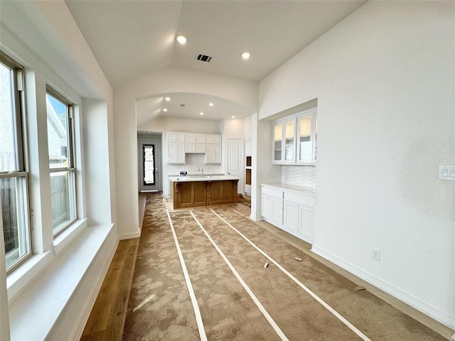 interior space with sink, carpet floors, and lofted ceiling