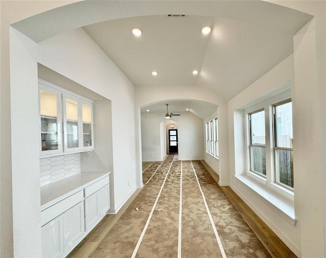 corridor featuring vaulted ceiling and hardwood / wood-style flooring