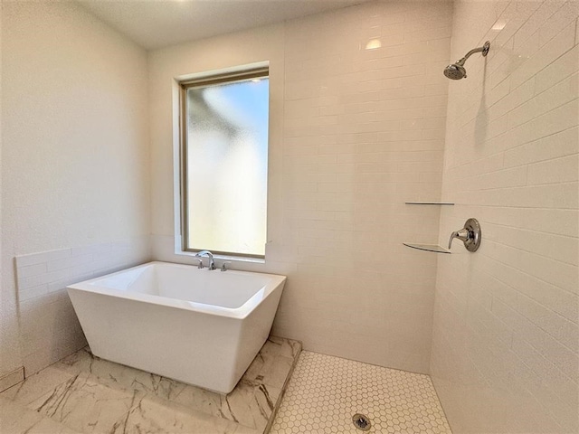 bathroom featuring plus walk in shower and tile walls