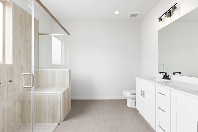 bathroom featuring toilet, tile patterned flooring, a shower with shower door, and vanity