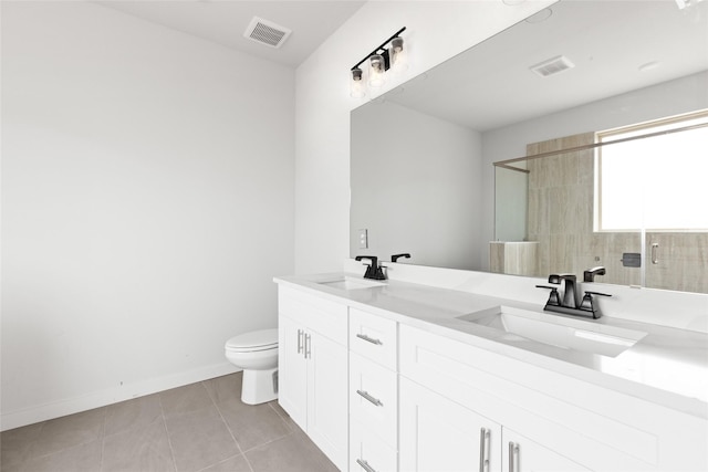 bathroom featuring toilet, vanity, tile patterned flooring, and a shower