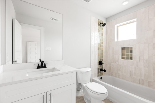 full bathroom featuring toilet, tiled shower / bath combo, wood-type flooring, and vanity