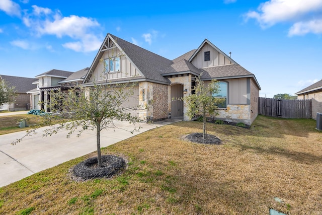 view of front of home with central AC and a front yard