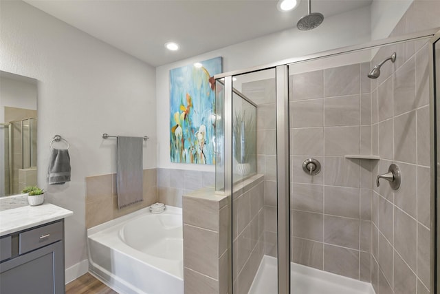 bathroom with vanity, wood-type flooring, and shower with separate bathtub