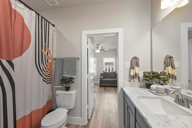 bathroom featuring toilet, vanity, wood-type flooring, and ceiling fan