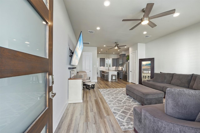 living room with light hardwood / wood-style floors and ceiling fan