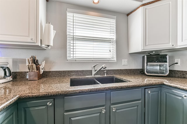 kitchen featuring white cabinets, plenty of natural light, and sink