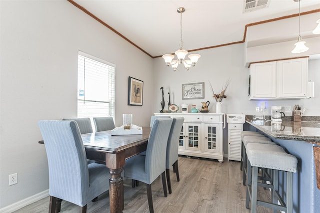 dining space featuring a notable chandelier and light hardwood / wood-style floors