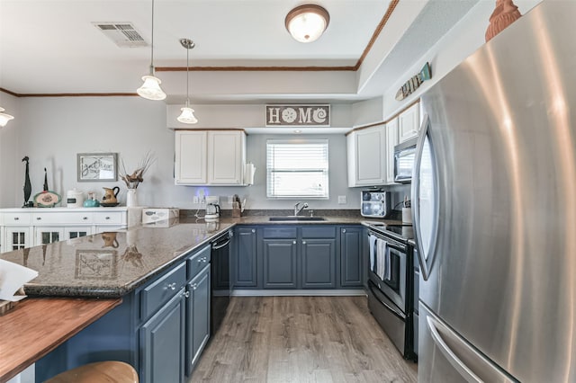 kitchen with white cabinetry, stainless steel appliances, dark stone counters, hanging light fixtures, and blue cabinets