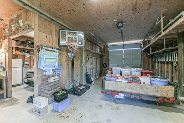 garage featuring white refrigerator and a garage door opener