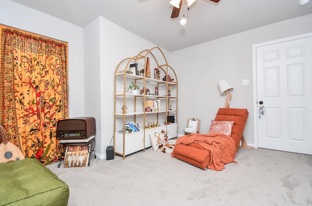 living area with ceiling fan and carpet