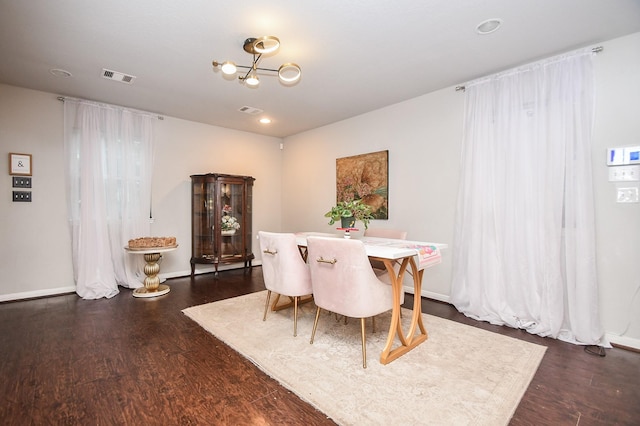 dining area featuring dark hardwood / wood-style floors and a chandelier