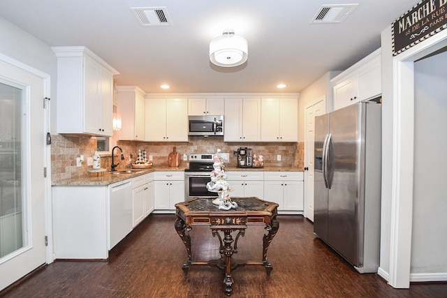 kitchen featuring white cabinets, appliances with stainless steel finishes, sink, and light stone counters